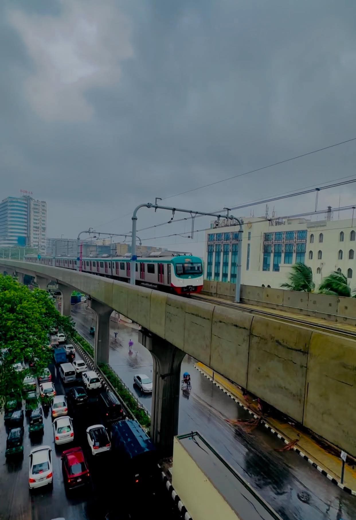 বৃষ্টিস্নাত দিনে ছুটে আসছে মেট্রোরেল।
লোকেশন: শাহবাগ, ঢাকা, বাংলাদেশ।