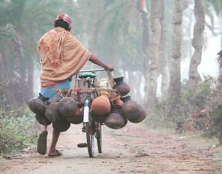 শীতের সকালে মাটির হাড়িতে খেজুরের রস সংগ্রহ করে সাইকেল দিয়ে নিয়ে যাওয়ার সুন্দর দৃশ্য।